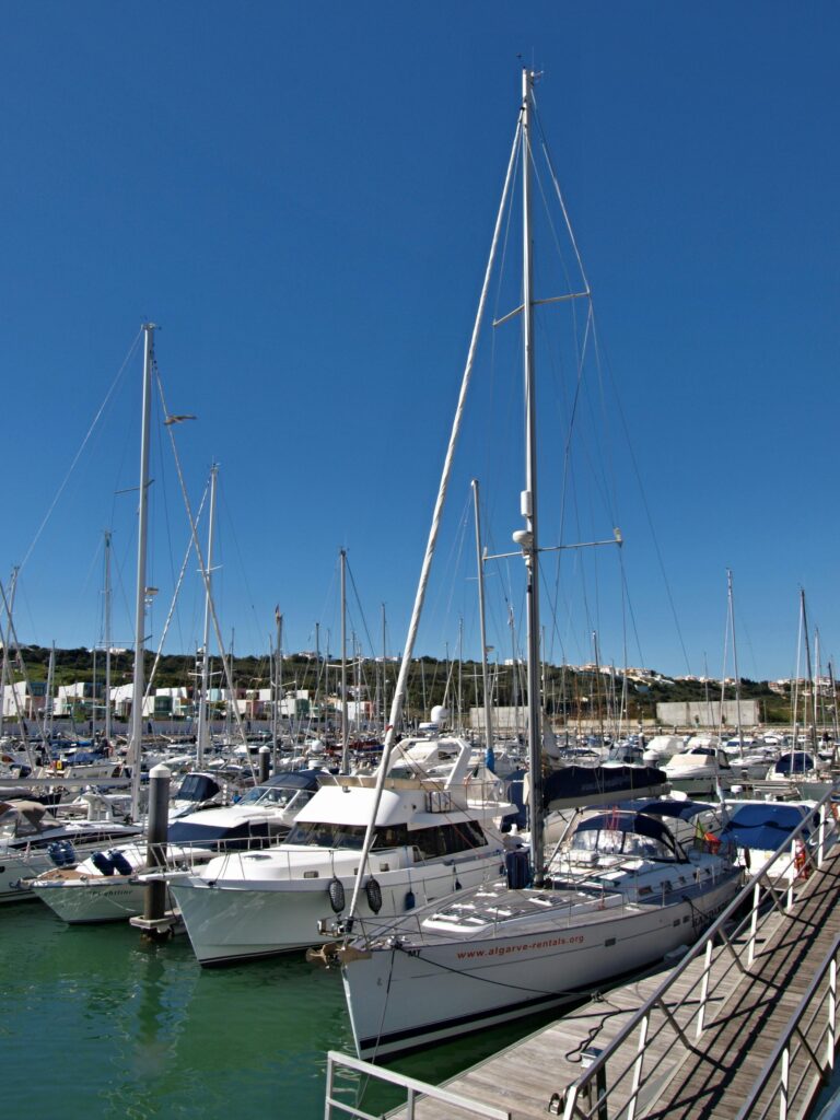 A scenic view of sailboats docked at the marina in Albufeira, Portugal on a sunny day.